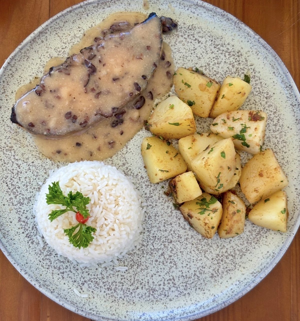 The plate from above: fish in cacao honey sauce, rice and sautéed potatoes.