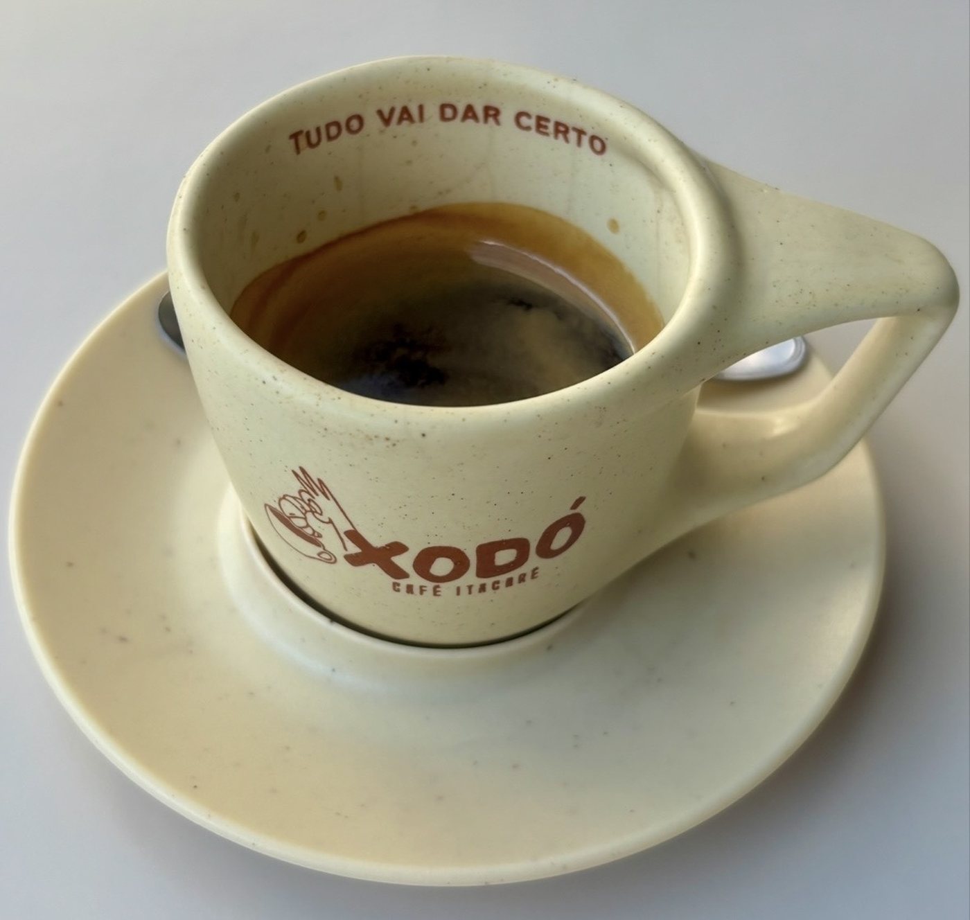 The Café Xodó cup from the side, the name on the china.