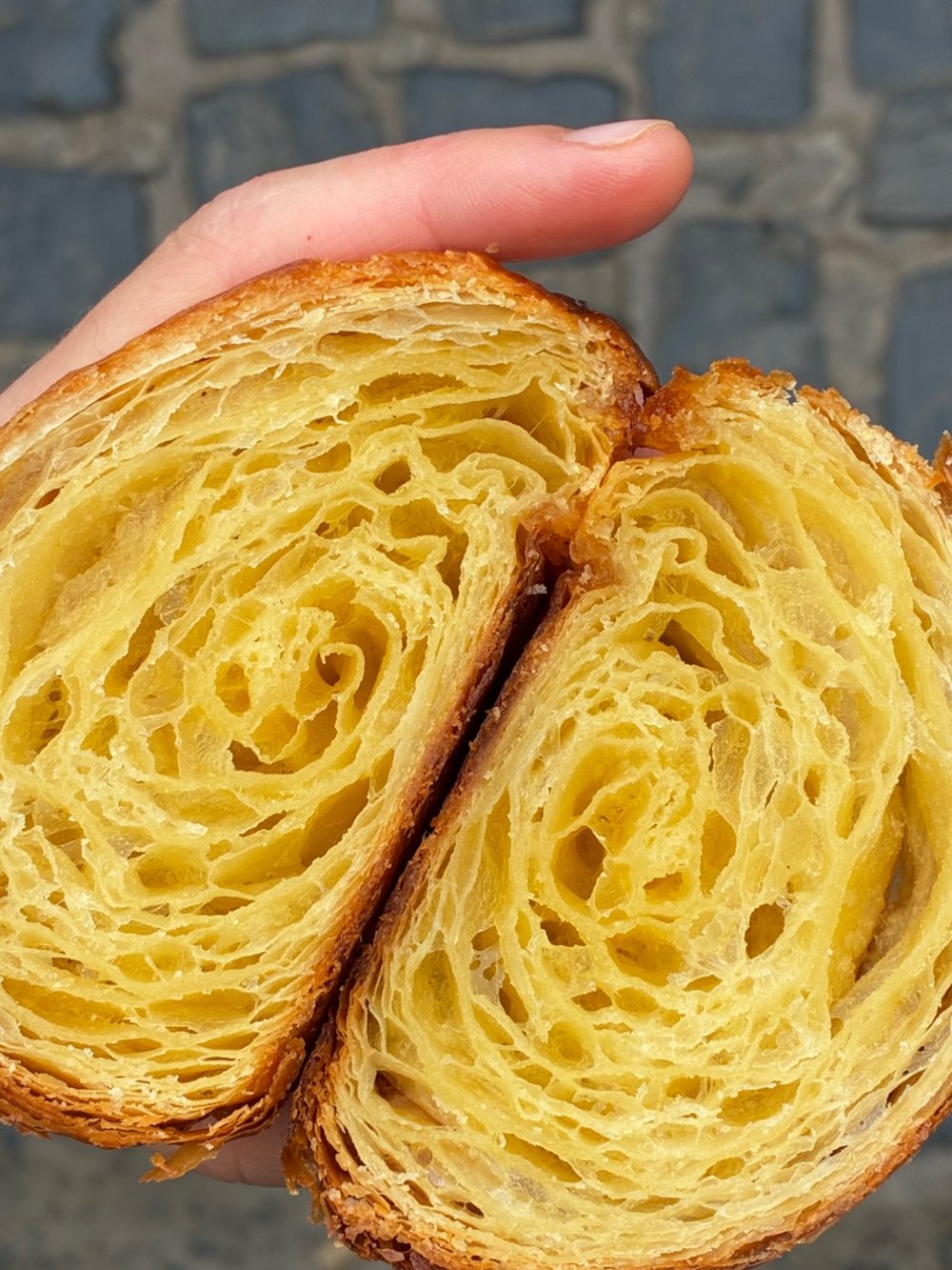 A medialuna cut in half, showing the layers of the pastry.